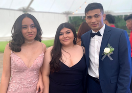 group of friends in prom dresses and suits